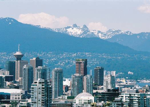 BC tax forms with Vancouver skyline in the background, representing provincial tax breaks in British Columbia