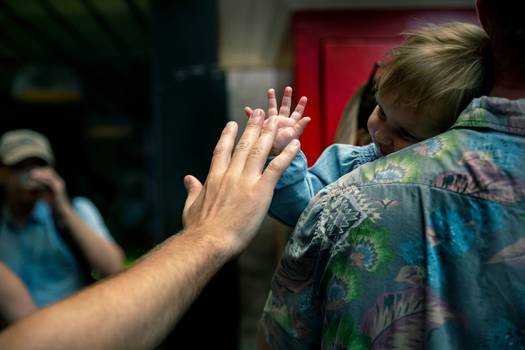 A parent dropping off a child at a Canadian daycare, with caregivers and children in a safe, nurturing environment