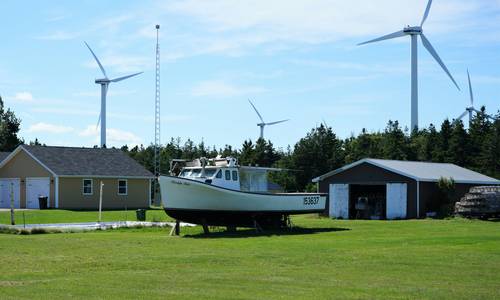 Modern Canadian factory with solar panels, wind turbines, and engineers reviewing sustainability plans