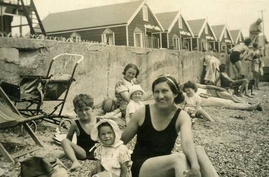 A smiling Canadian family holding keys in front of a new house, symbolizing first-time home ownership and incentives