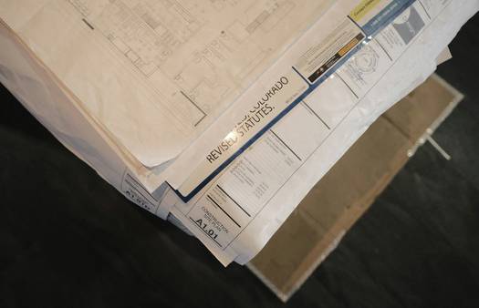 A Canadian investor reviewing a capital gains tax statement with a graph and real estate documents on a desk