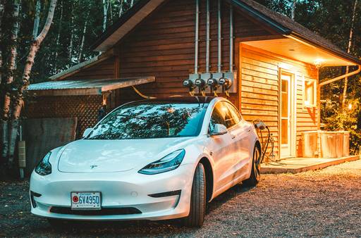 A Canadian family charging an electric car at home with solar panels, illustrating climate action incentives and rebates
