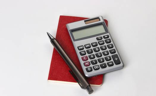 A Canadian GST/HST rebate form and home purchase paperwork with a calculator and pen on a desk