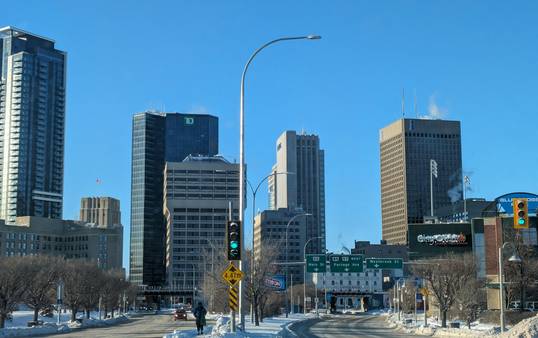 Downtown Winnipeg business district skyline with modern office towers and a business team in discussion