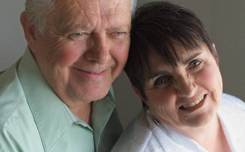 Nova Scotia senior couple at home, reviewing paperwork and smiling