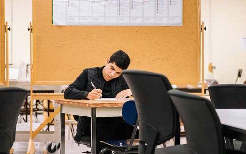 Nova Scotia university student studying with textbooks and tax paperwork