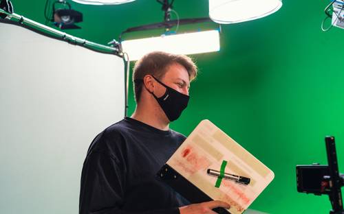 Ontario digital media studio with a production team, film camera on set in Toronto, and a stack of published books