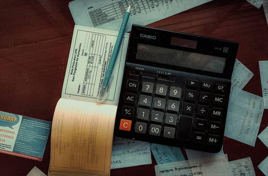 A Canadian piggy bank with RRSP and TFSA labels, stacked paperwork, and a calculator—illustrating savings and retirement planning