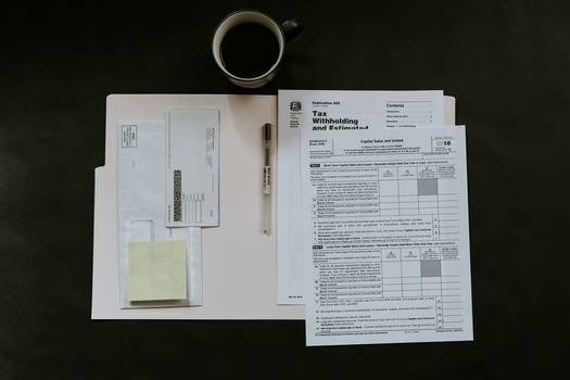A Canadian entrepreneur organizing receipts and tax paperwork at a desk, with a laptop and calculator